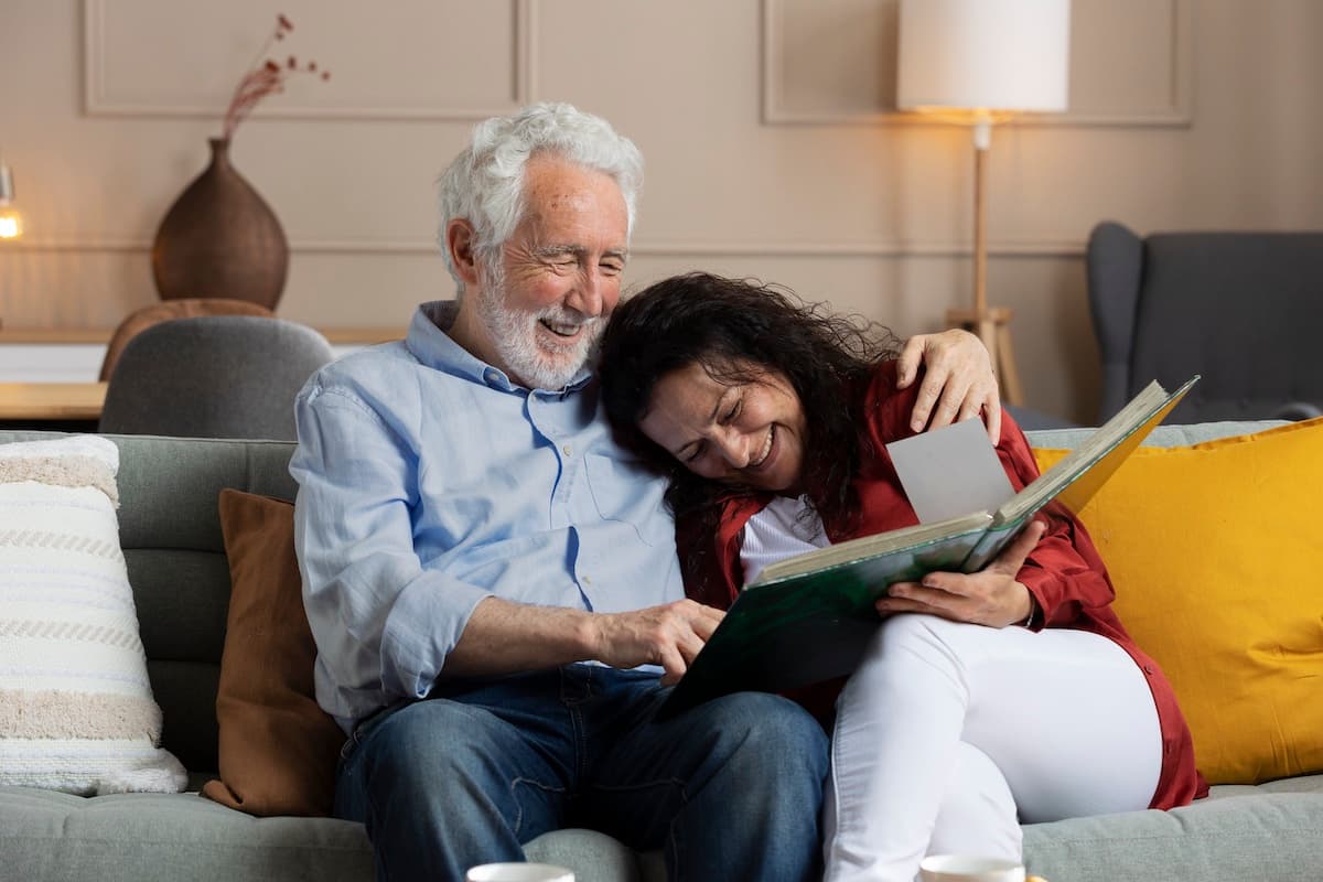 A family smiles while looking at photo albums together